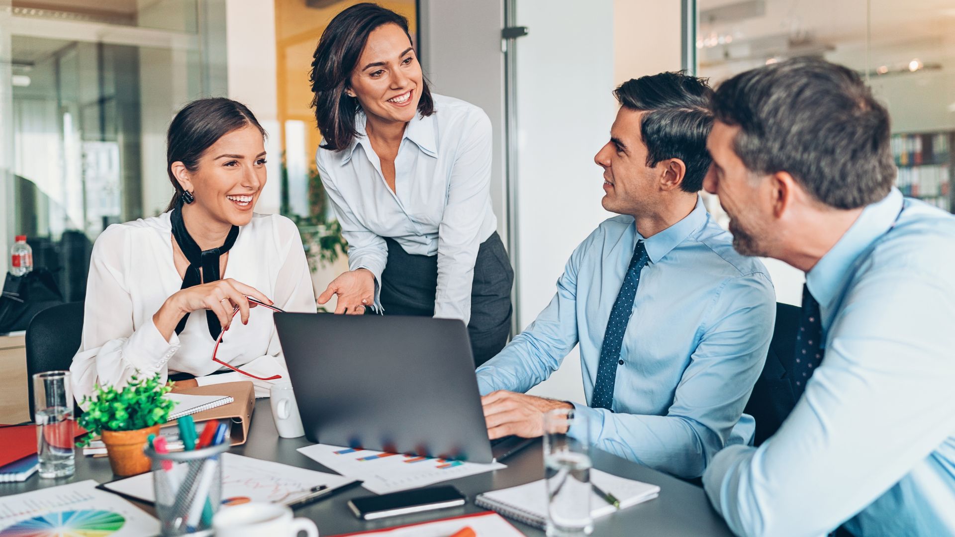 Equipo de trabajo reunido en una oficina utilizando un portátil